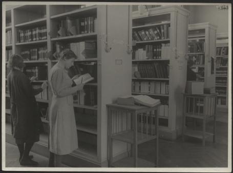 Обложка книги Сотрудницы у стилажей с книгами Фотография
