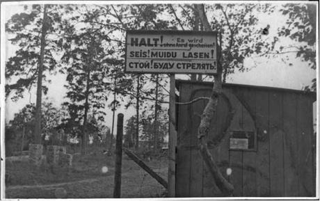 Обложка книги Лагерь смерти в поселке Клоога вывеска у концлагеря: "Стой, буду стрелять". 25 сентября 1944 г. фотография